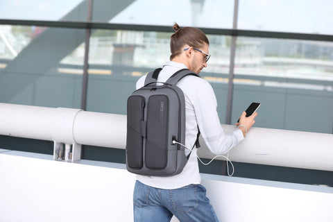Mann am Flughafen mit smartem Laptoprucksack