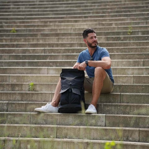 Mann auf Treppe mit Reiserucksack