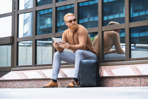 Mann am Flughafen mit Laptoprucksack