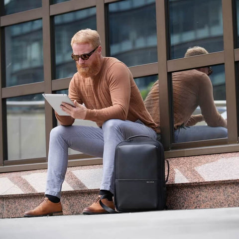 Mann mit BANGE 15 Zoll  Laptoprucksack UX vor Geschäftshaus.